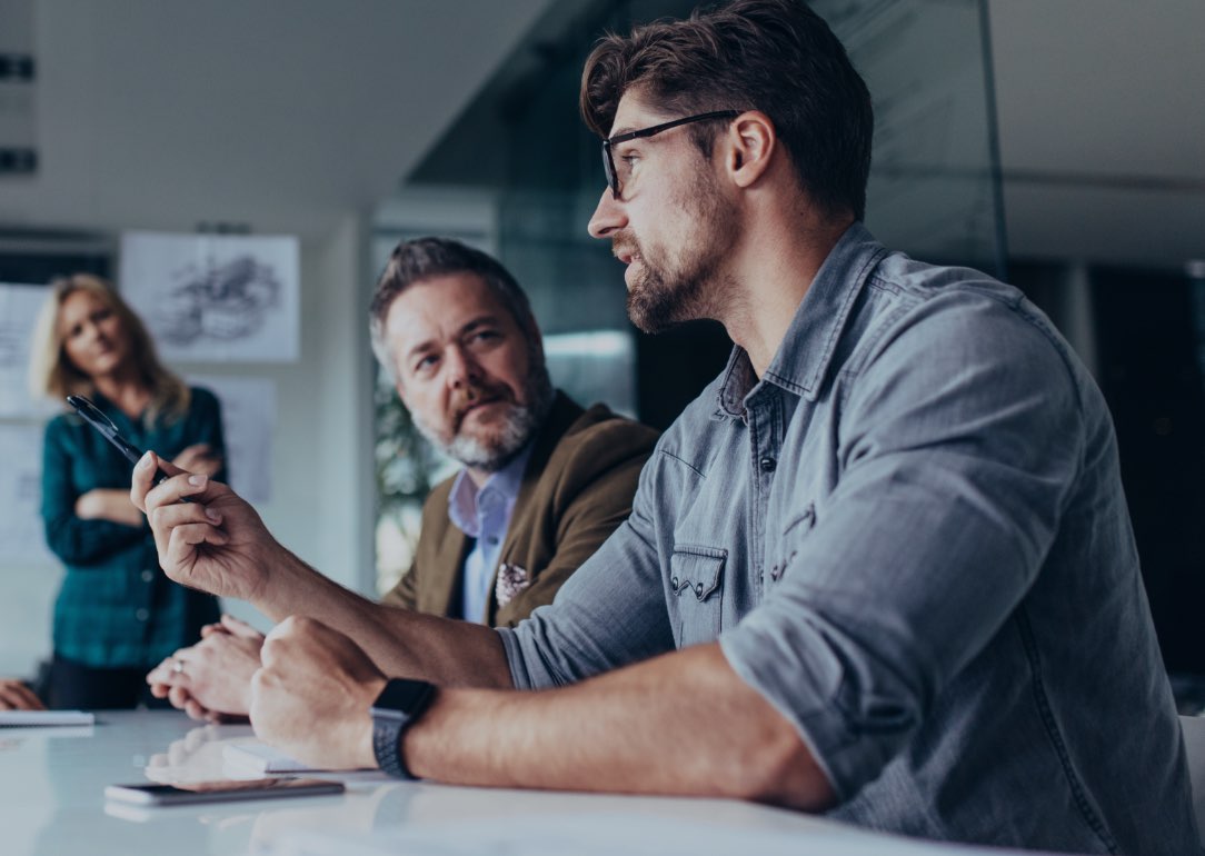 3 people having a meeting in a conference room